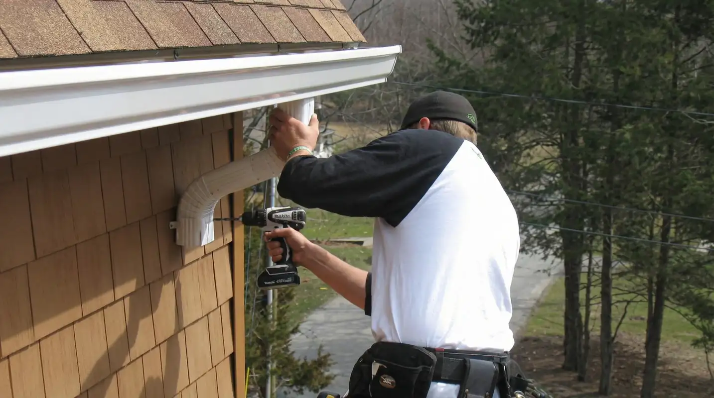Professional contractor installing tan vinyl siding panels on a residential home exterior in Arlington, TX